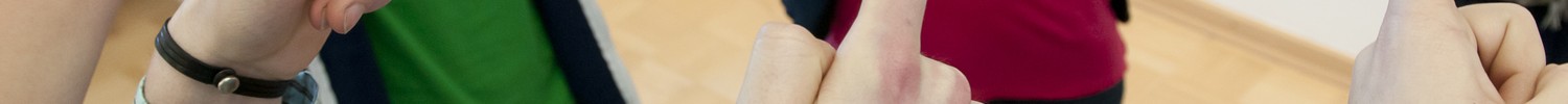 Einige FreD-Kursteilnehmer*innen heben gemeinsam mit den Zeigefingern einen Hula-Hoop-Reifen auf.